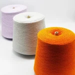 Three-color viscose nylon boucle yarn cones in orange, white, and lavender for custom shade development