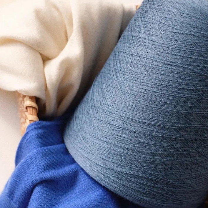 Blue bio-based yarn cone for textile production and knitting applications