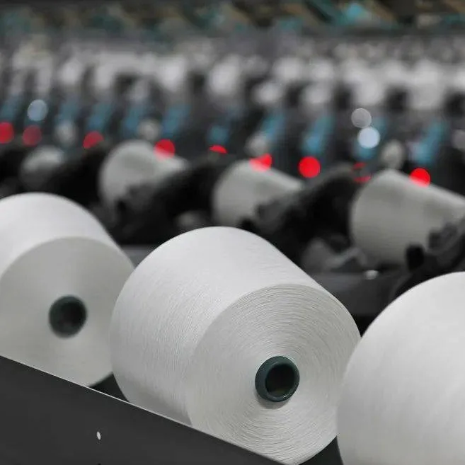 White yarn cones in a textile spinning mill representing yarn production quality and large-scale manufacturing consistency